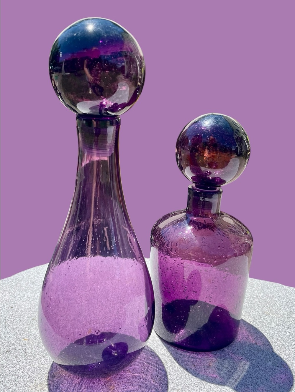 2 blown glass decanters, large round stoppers, amethyst color, lots of bubbles